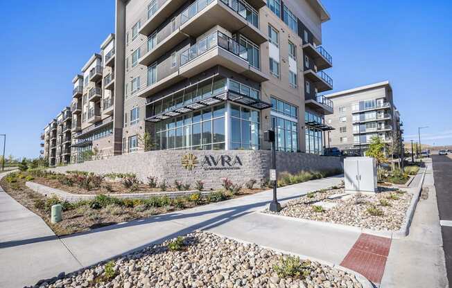 an apartment building with a sign on the side of a sidewalk