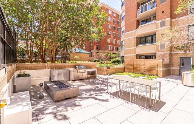 a patio with a table and chairs and a fire pit