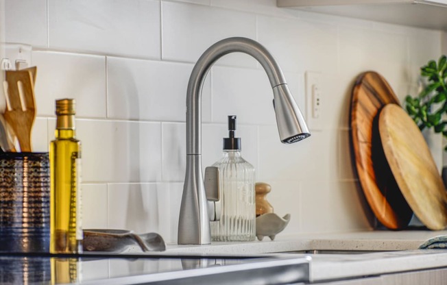 a kitchen sink with a faucet and a bottle of soap on it