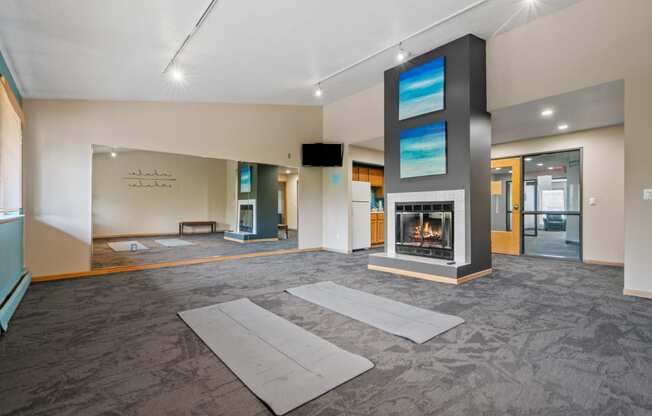 a large living room with a fireplace and yoga mats