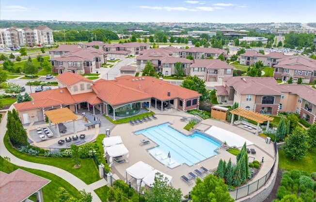 an aerial view of a swimming pool in a neighborhood with houses