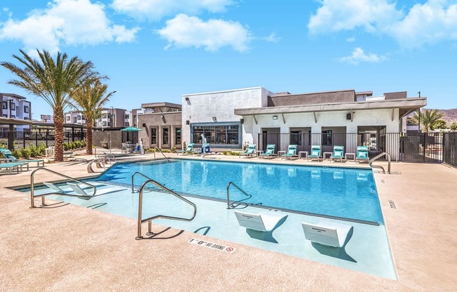 Luxurious modern apartment complex featuring a sparkling swimming pool with sun loungers and lush palm trees, perfect for relaxation and leisure at Summit on Boulder Apartments.