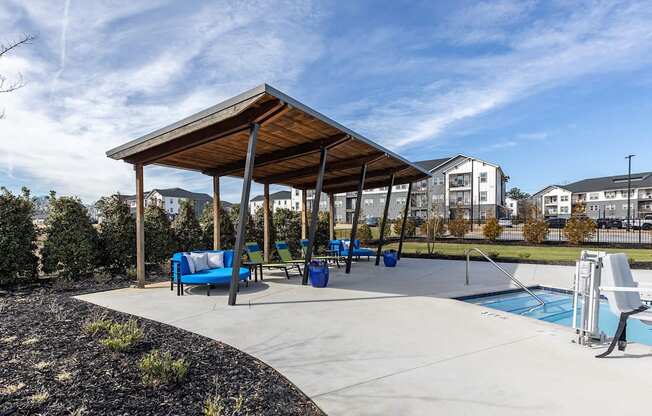 a canopy over a playground with a pool and chairs