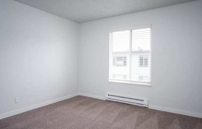 an empty room with white walls and a window