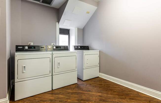 an empty laundry room with white appliances and a window