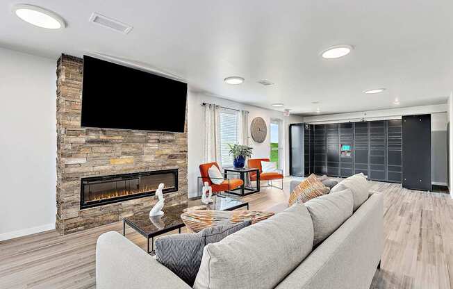 A living room with a stone fireplace and a grey couch.