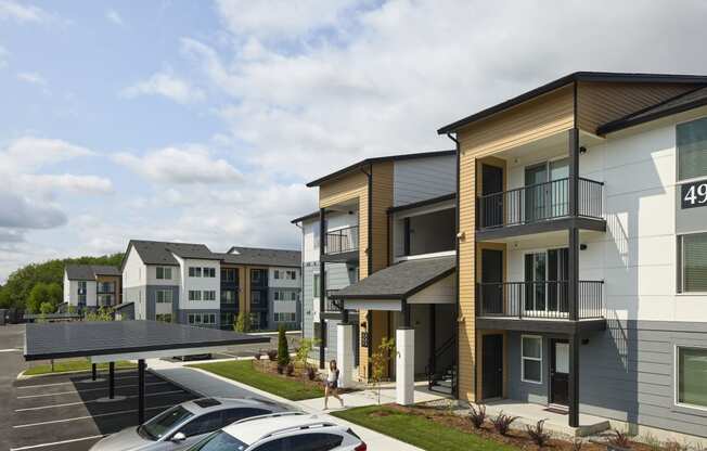 a rendering of a row of townhomes with cars parked in a parking lot