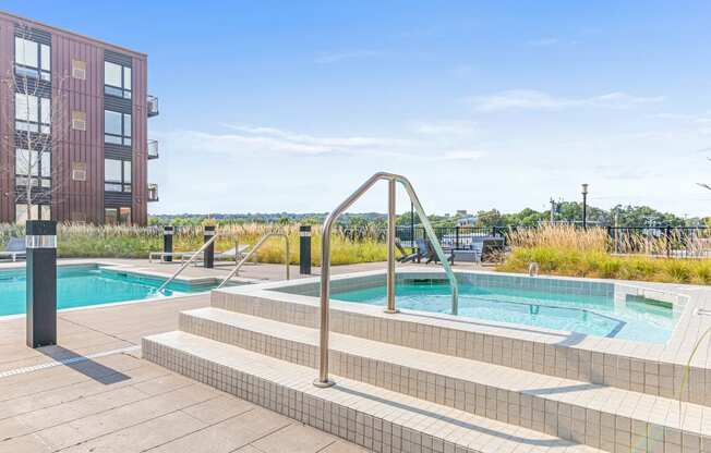 a pool and spa with a building in the background