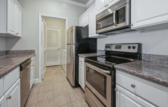 a kitchen with white cabinets and stainless steel appliances