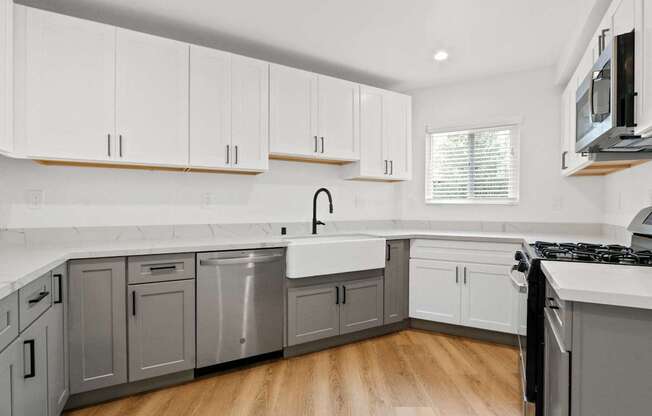 a kitchen with white cabinets and stainless steel appliances