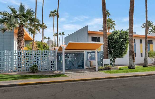 A building with a blue and white facade is surrounded by palm trees at The Phoenix Apartments on 6th Avenue, Arizona 85013