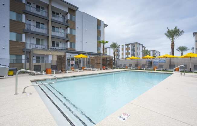 South Scottsdale, AZ Apartments - Lucent Scottsdale - Sparkling Pool With Tanning Ledge, Cabanas, Lounge Chairs, Tables, And Umbrellas