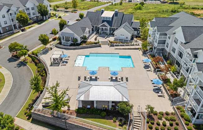 an aerial view of a large swimming pool in front of a row of houses