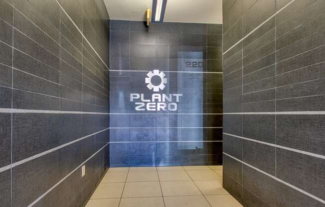 the entrance to a plant zero bathroom with a large sign on the side of it