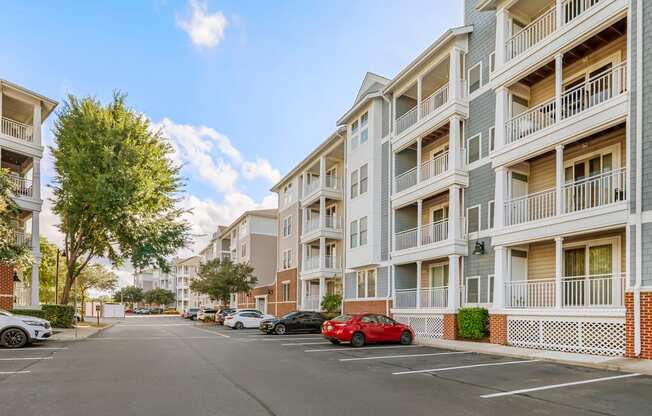 A street view of a residential area with cars parked on the side.