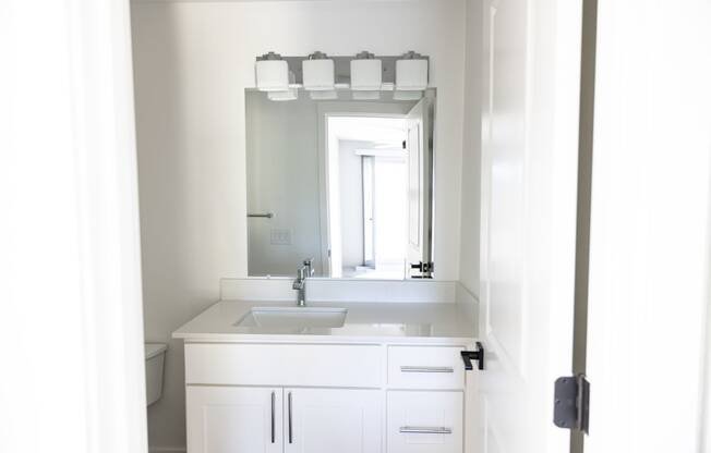 a white bathroom with a sink and a mirror