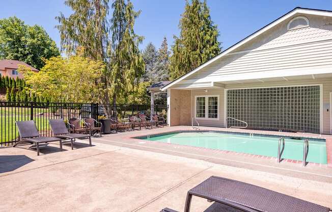 a swimming pool in front of a house with patio furniture at Murrayhill Park, Beaverton Oregon