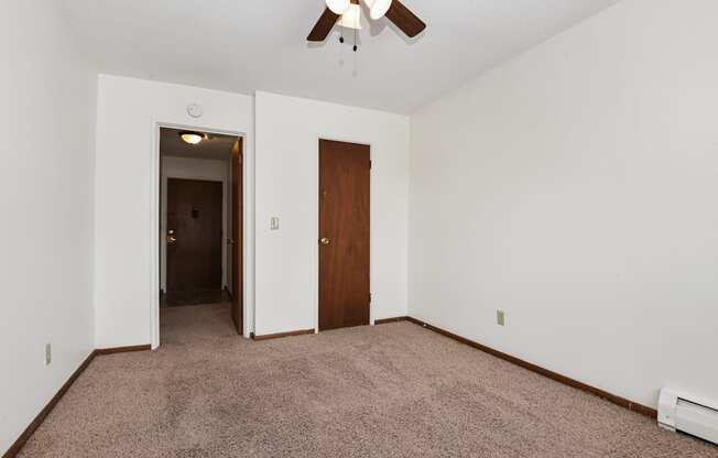 West St. Paul, MN Covington Courts Apartments. A  bedroom with a ceiling fan and a door to a hallway