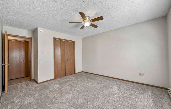 an empty living room with a ceiling fan at Creekstone Falls, Sioux Falls, SD