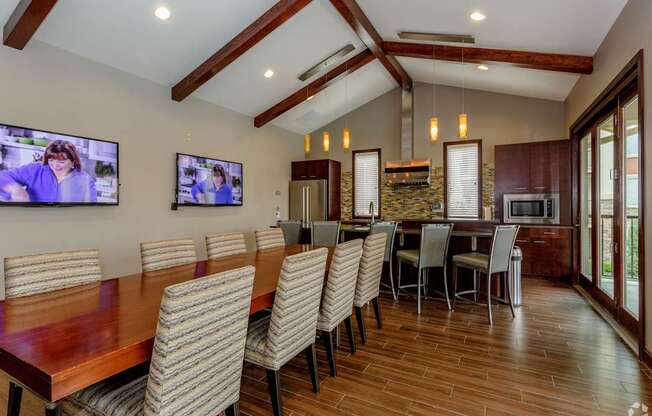 A modern dining room with a long wooden table and chairs.