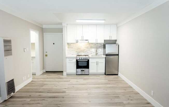 a kitchen with white cabinets and a stove and a refrigerator