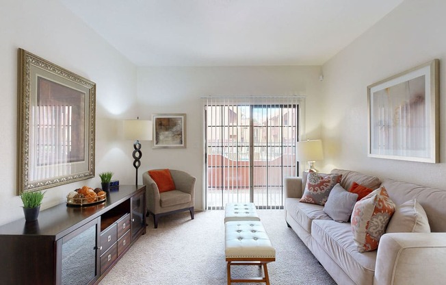 a living room with a couch chair and ottoman