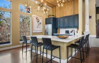 a kitchen with a large center island with a marble countertop