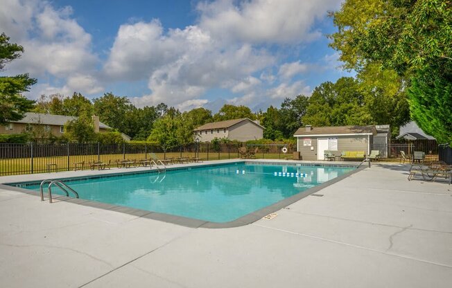 a swimming pool with trees and a fence around it