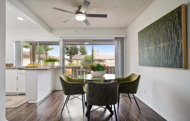 a dining area with a table and chairs and a ceiling fan