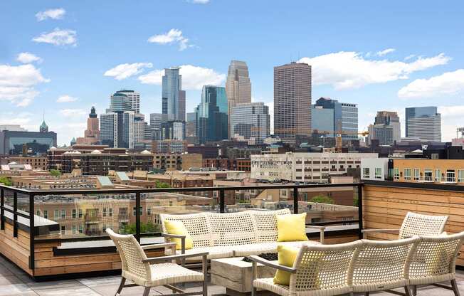 A patio with a table and chairs overlooking a city skyline.