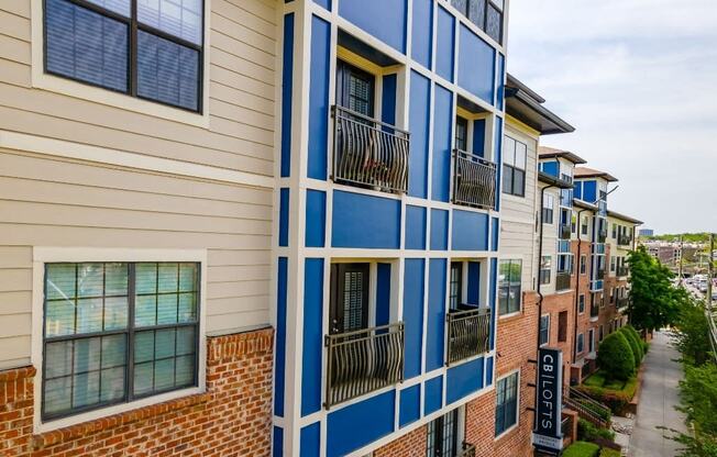 a view of a building with balconies and a sidewalk