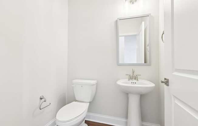 A white toilet and sink in a small bathroom.