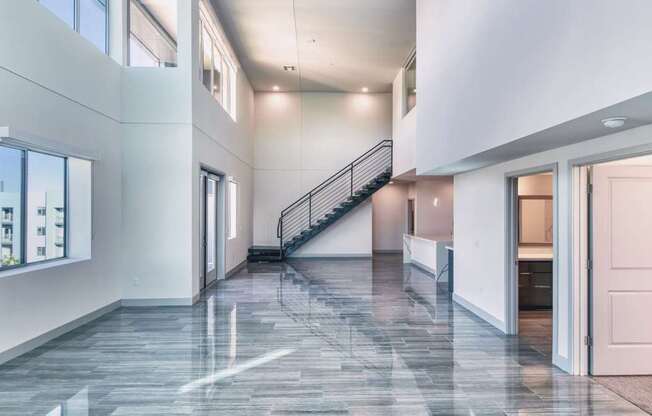 A spacious interior with a marble floor and a staircase.
