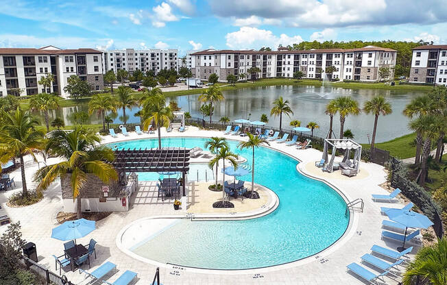 Beach-entry saltwater pool with sun shelves and cabanas overlooking private lake