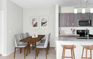 A kitchen with a dining table and chairs.