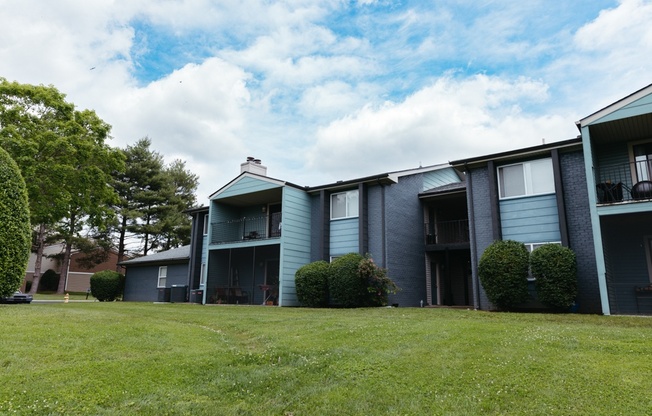 an apartment building with a green lawn in front of it