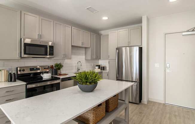 a kitchen with stainless steel appliances and a marble counter top