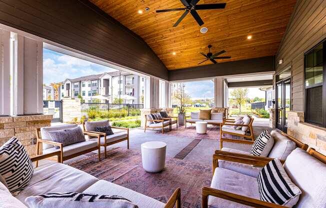 Covered patio with couches and chairs and a tv at The Parker Austin, Texas