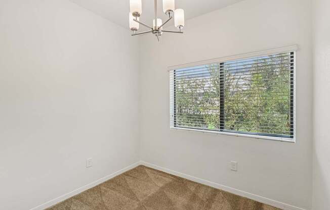 A room with a window covered by horizontal blinds.