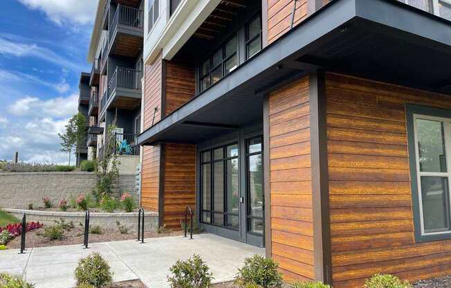 A modern building with wooden sidings and glass doors.