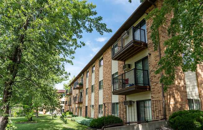 Exterior view of a brick apartment building with balconies. Fargo, ND Granger Court Apartments.