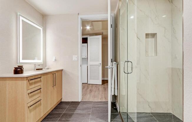 a bathroom with a shower and a sink and a mirror