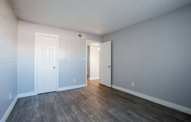 an empty living room with wood flooring and a white door