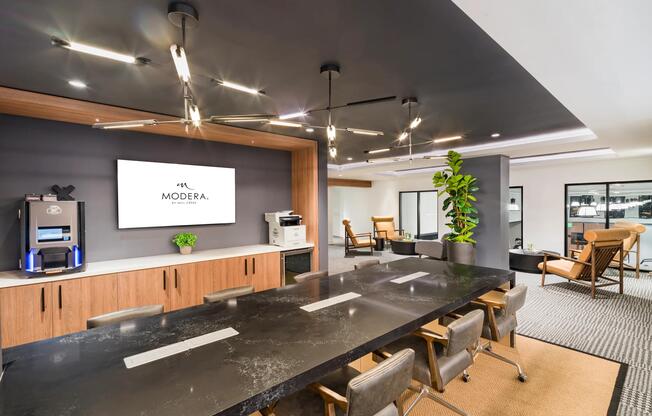 A design-forward conference space at Modera Aventura, featuring integrated technology, warm wood accents, and flexible seating for focused work or collaboration.
