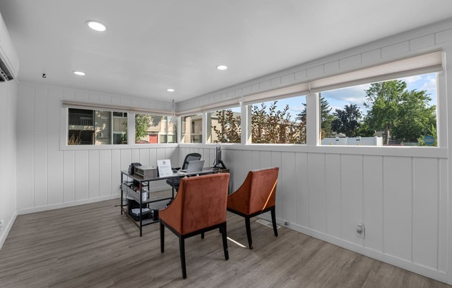 a home office with windows and a desk with a computer