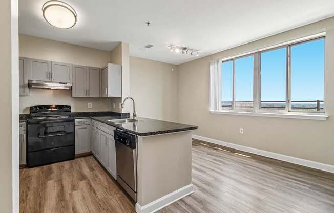 A kitchen with a black countertop and stainless steel appliances.
