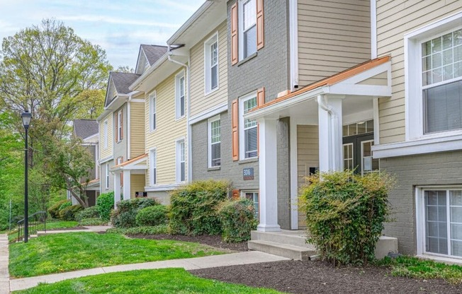 A row of houses with green lawns in front.