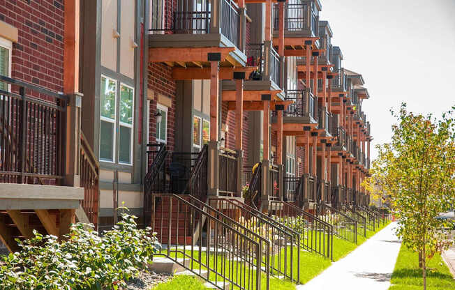 A long row of red brick apartment buildings with balconies.