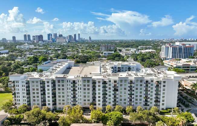 an aerial view of an apartment building with the city skyline in the background