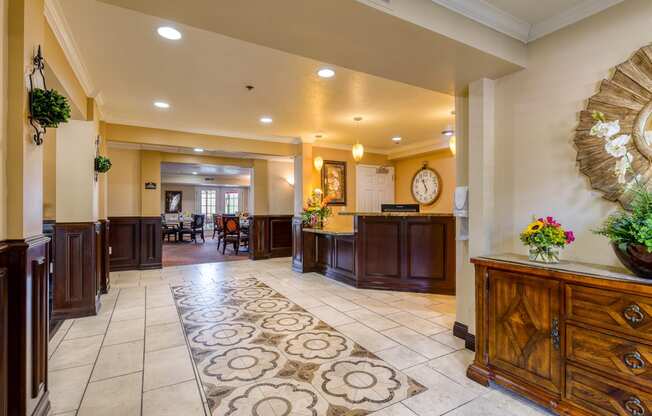 a lobby with a large rug and wooden furniture